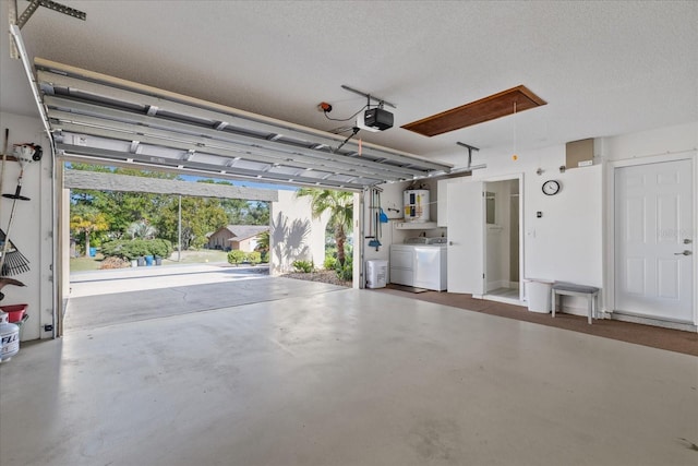 garage featuring a garage door opener, water heater, and washing machine and clothes dryer