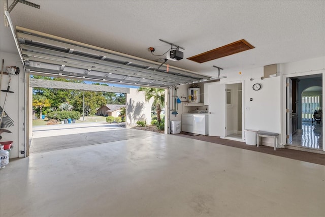 garage with a garage door opener, washer and dryer, and water heater