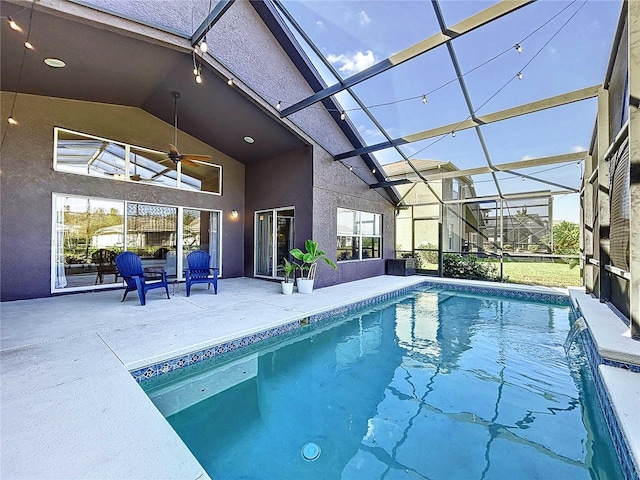 view of pool featuring a patio area, glass enclosure, pool water feature, and ceiling fan