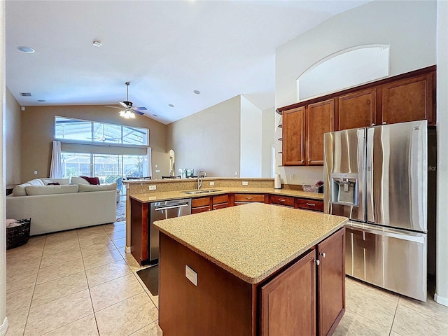 kitchen featuring lofted ceiling, kitchen peninsula, a kitchen island, appliances with stainless steel finishes, and sink