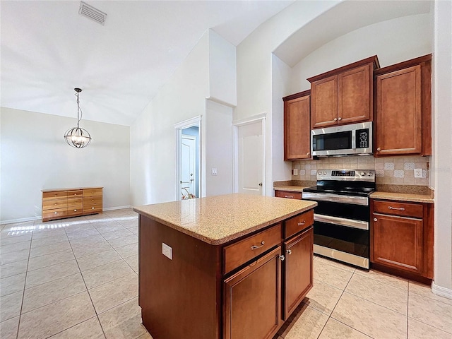 kitchen with tasteful backsplash, a kitchen island, hanging light fixtures, stainless steel appliances, and light tile patterned floors