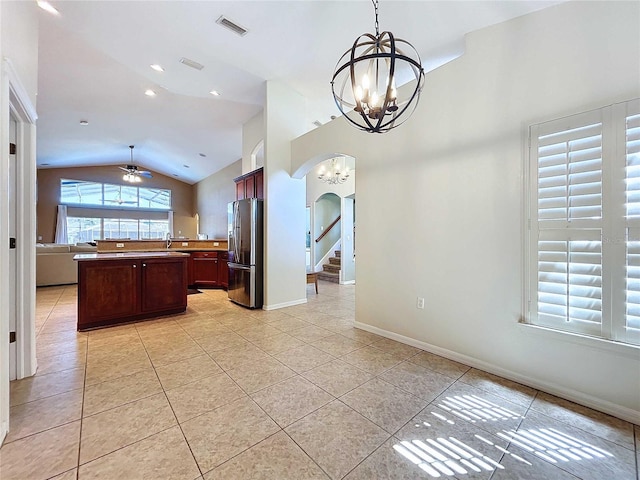 kitchen with stainless steel refrigerator with ice dispenser, a center island, vaulted ceiling, pendant lighting, and light tile patterned floors