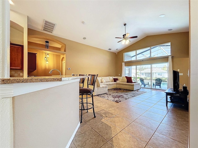 tiled living room with sink, ceiling fan, and lofted ceiling