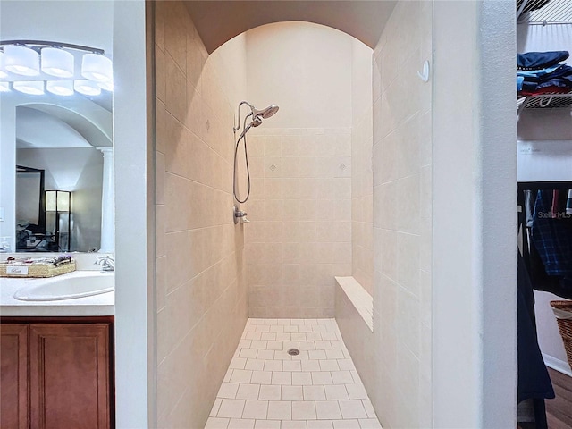 bathroom with a tile shower and vanity