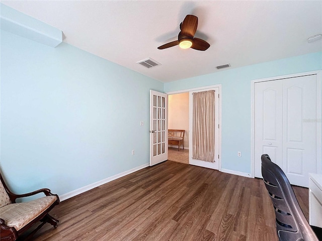 unfurnished office featuring french doors, dark hardwood / wood-style floors, and ceiling fan