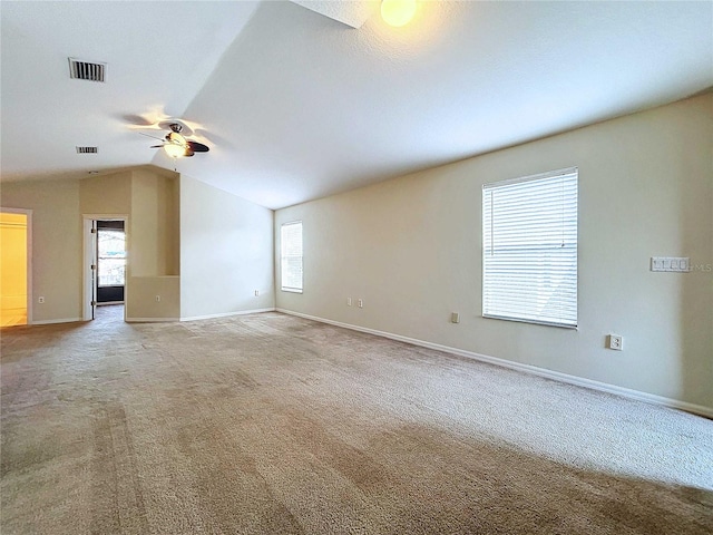 carpeted spare room featuring ceiling fan and vaulted ceiling