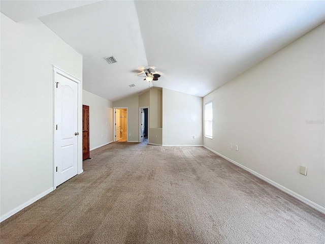 carpeted spare room with ceiling fan and vaulted ceiling