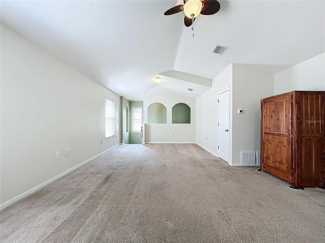 unfurnished living room featuring lofted ceiling, light colored carpet, and ceiling fan