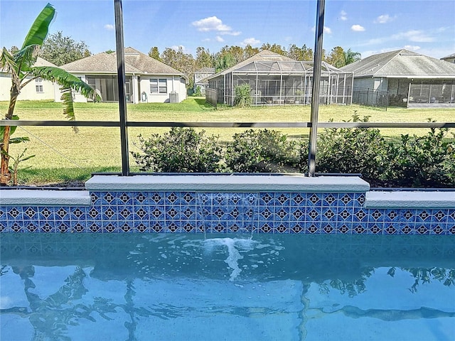 view of pool featuring a lanai and a lawn