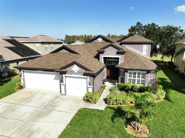 view of front of house featuring a garage and a front lawn