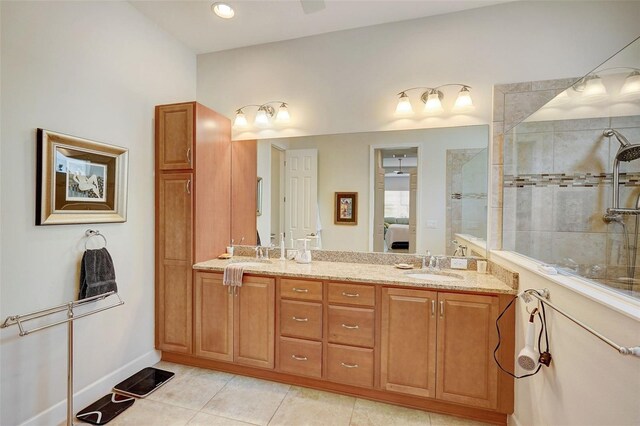 bathroom with vanity, a tile shower, and tile patterned floors