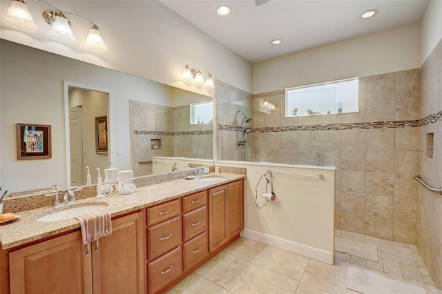 bathroom with a tile shower, tile patterned floors, plenty of natural light, and vanity