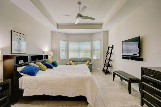 tiled bedroom with a raised ceiling and ceiling fan