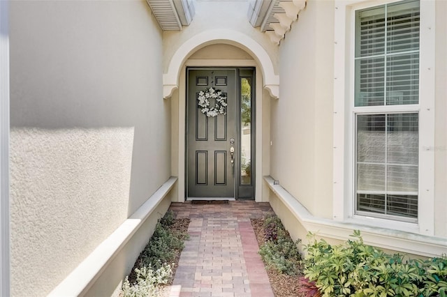 1804 Pacific Dunes Dr, Sun City Center, FL 33573 - doorway to property featuring stucco siding and a wall unit AC