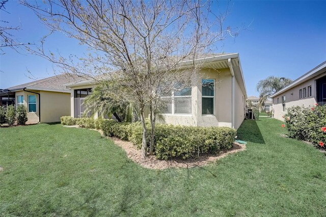 1804 Pacific Dunes Dr, Sun City Center, FL 33573 - back of house with stucco siding and a lawn
