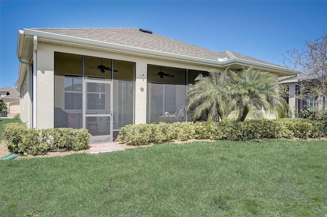 1804 Pacific Dunes Dr, Sun City Center, FL 33573 - back of house featuring ceiling fan, a lawn, roof with shingles, and stucco siding