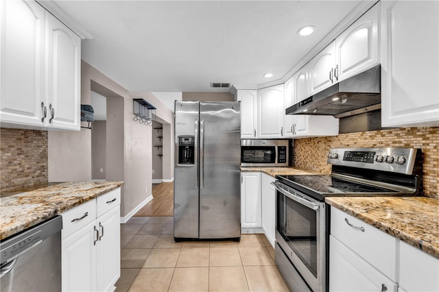 kitchen featuring white cabinetry, stainless steel appliances, light stone countertops, and light tile patterned flooring