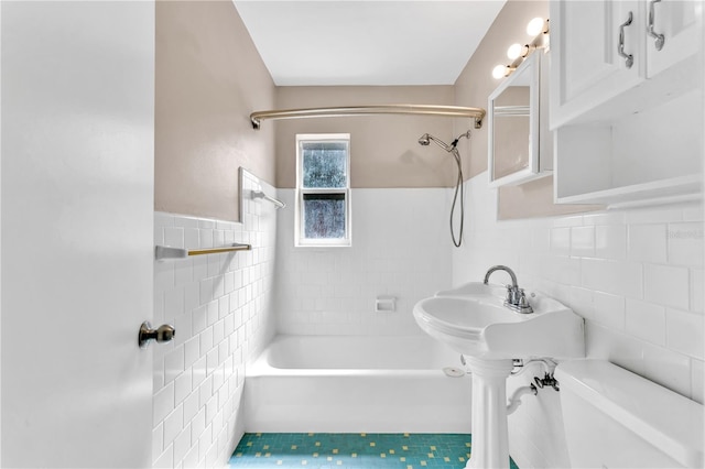 bathroom featuring tiled shower / bath, tile walls, and tile patterned flooring