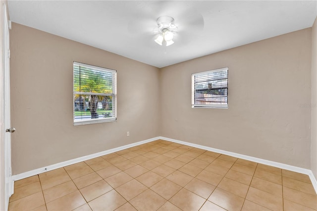 tiled empty room featuring ceiling fan and a healthy amount of sunlight