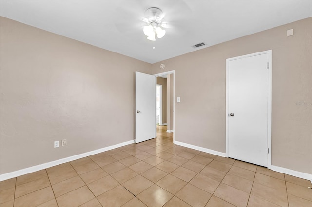 empty room featuring light tile patterned flooring and ceiling fan