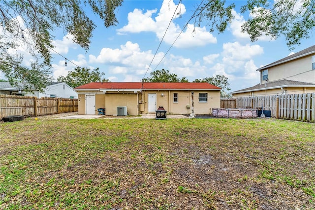 rear view of house featuring central AC, a yard, and a patio area