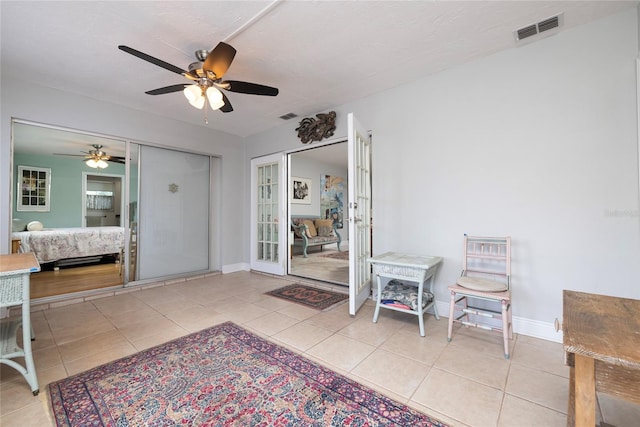 interior space with french doors, light tile patterned flooring, and ceiling fan