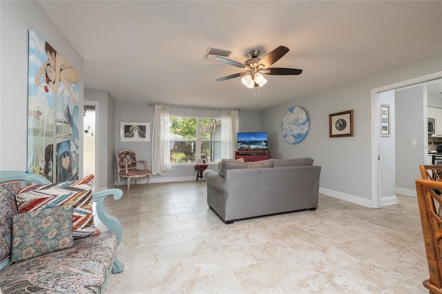 living room with a textured ceiling and ceiling fan