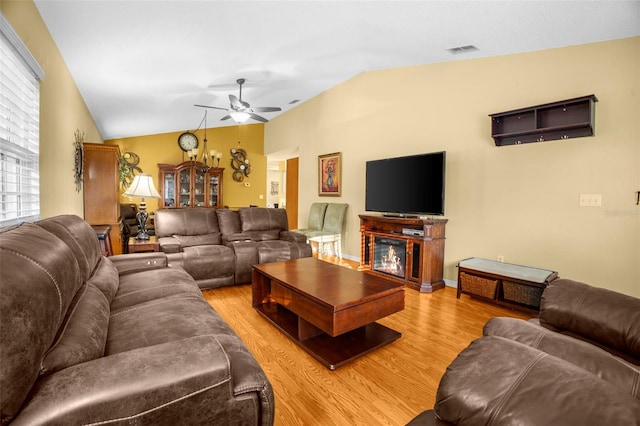 living area featuring a ceiling fan, visible vents, light wood-style flooring, and lofted ceiling