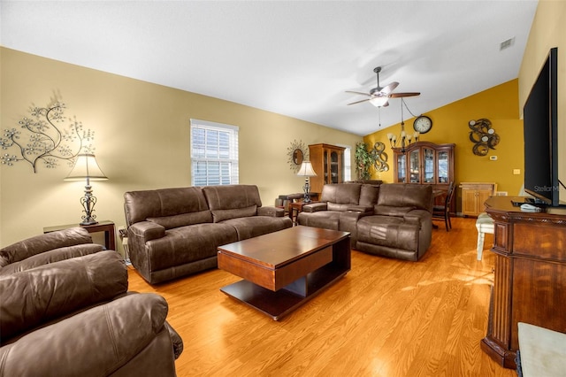 living room featuring ceiling fan, vaulted ceiling, light wood finished floors, and visible vents