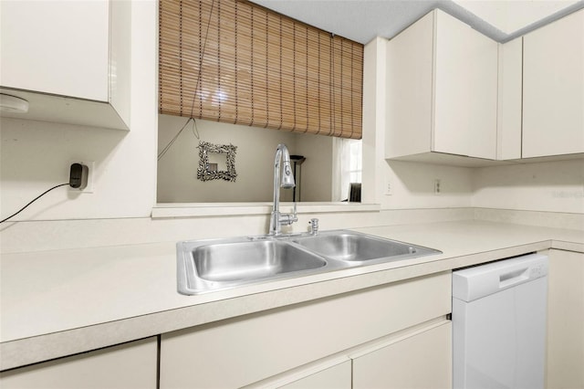 kitchen featuring light countertops, white cabinets, a sink, and dishwasher