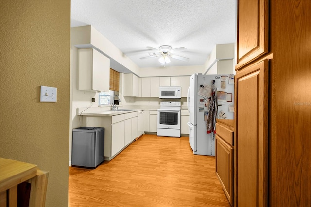 kitchen with white cabinets, ceiling fan, light wood-type flooring, and white appliances