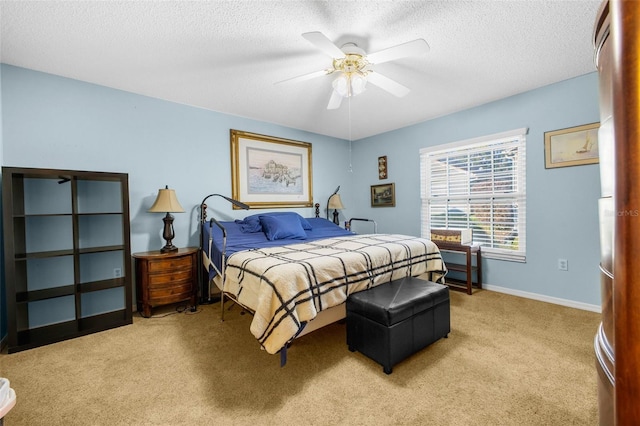 bedroom with baseboards, ceiling fan, a textured ceiling, and light colored carpet