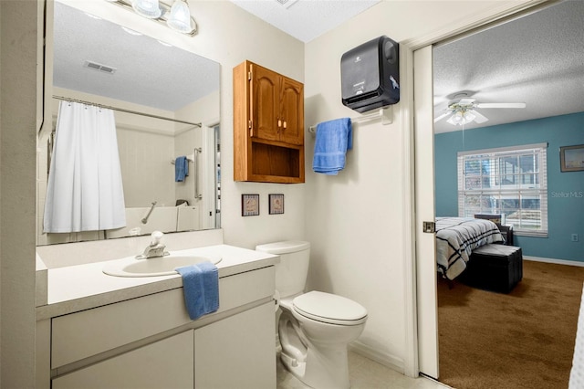 ensuite bathroom with toilet, a textured ceiling, visible vents, and ceiling fan