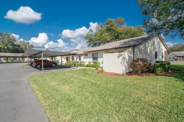 view of side of property featuring a lawn and covered parking