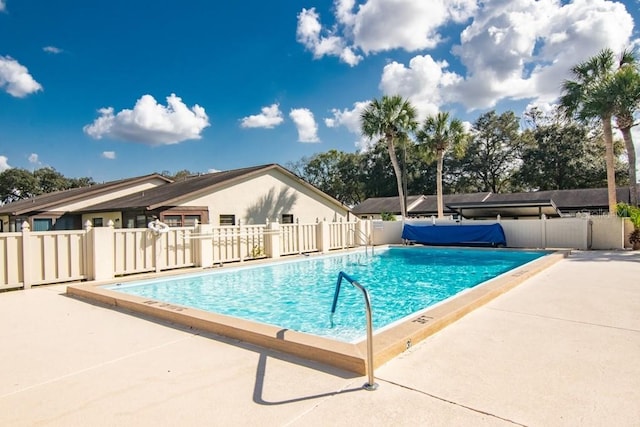 community pool with fence and a patio area