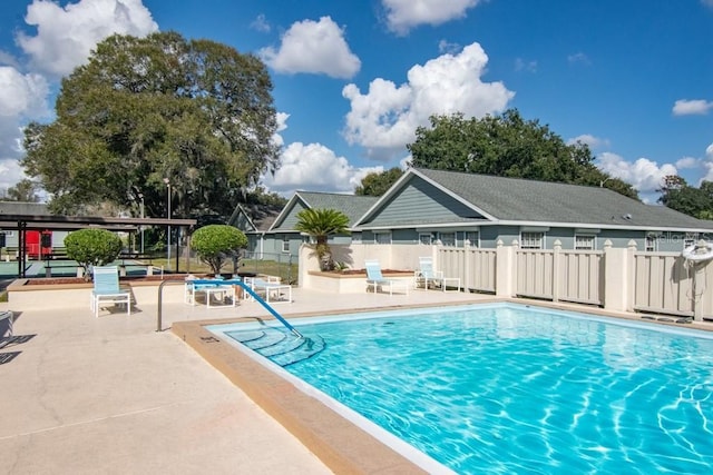 community pool featuring a patio and fence