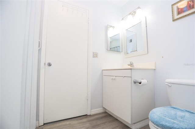 bathroom with vanity, wood-type flooring, and toilet