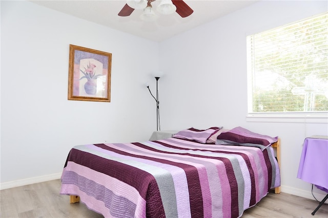 bedroom featuring multiple windows, light wood-type flooring, and ceiling fan