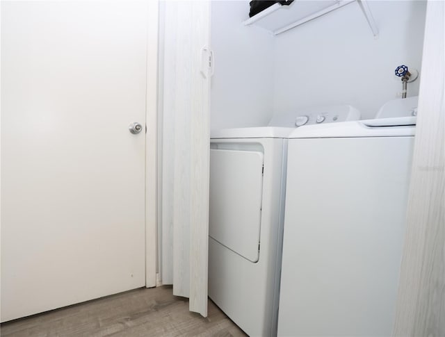 washroom with light hardwood / wood-style floors and separate washer and dryer