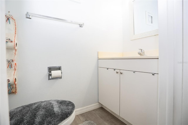 bathroom featuring vanity, hardwood / wood-style flooring, and toilet