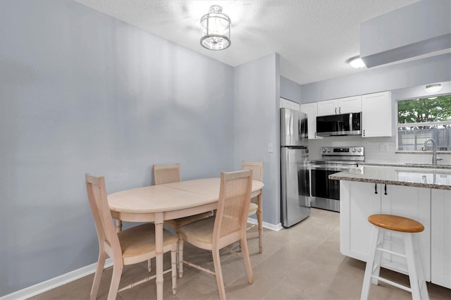 dining room with sink and a textured ceiling