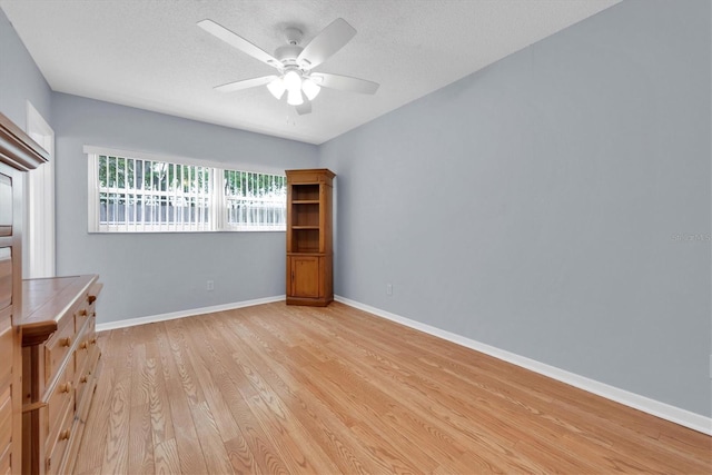 interior space featuring a textured ceiling, light wood-type flooring, and ceiling fan