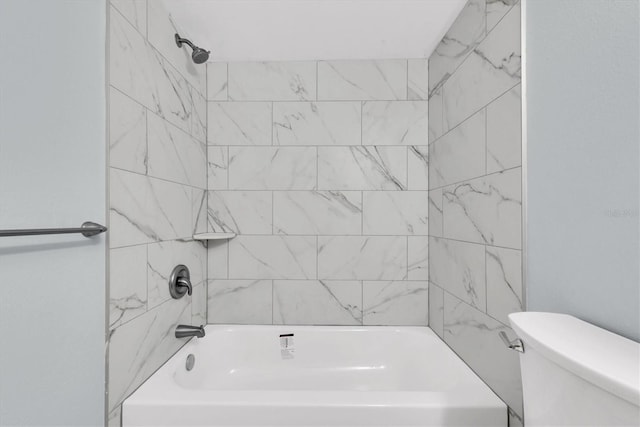 bathroom with tiled shower / bath combo and toilet