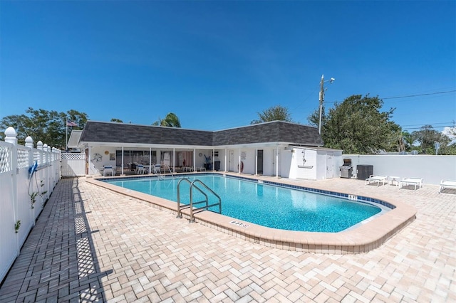 view of pool with a patio and central air condition unit