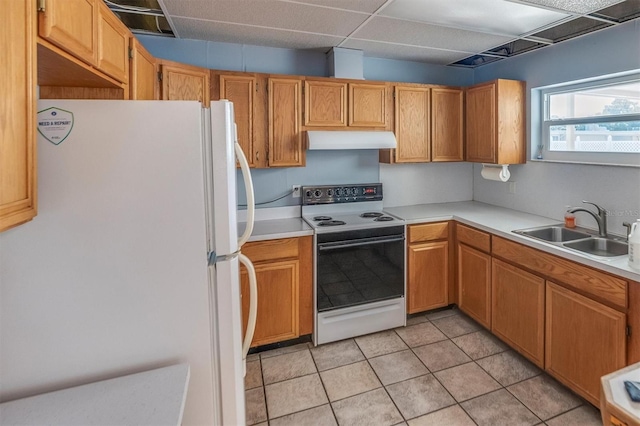 kitchen with white appliances, light tile patterned flooring, sink, and a drop ceiling