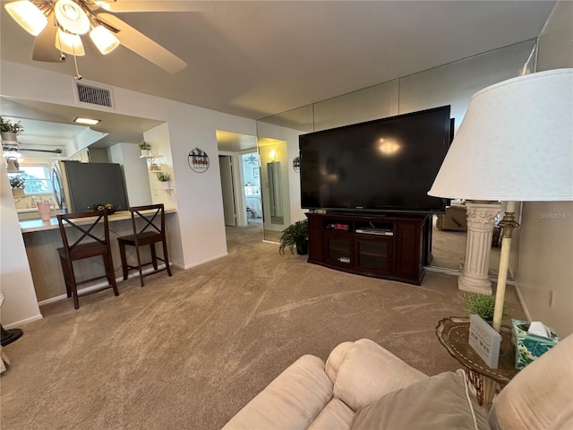 carpeted living room with ceiling fan