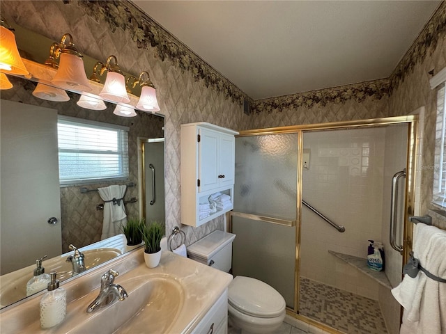 bathroom featuring vanity, a shower with shower door, toilet, and tile patterned floors