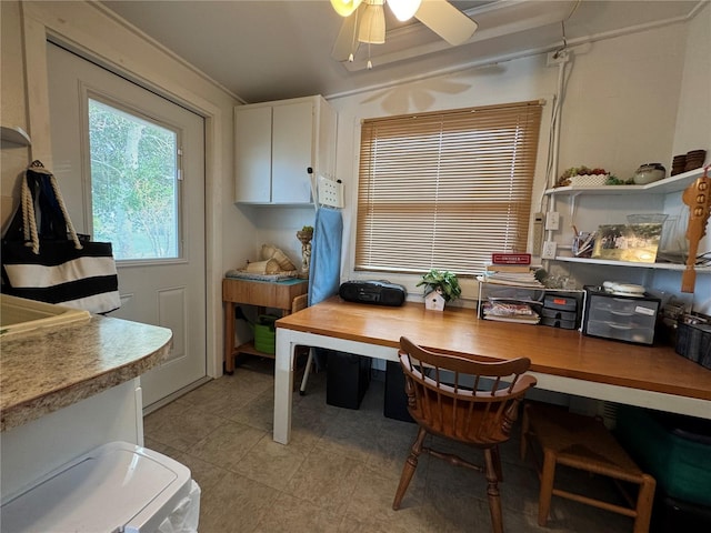 interior space featuring crown molding, built in desk, and ceiling fan