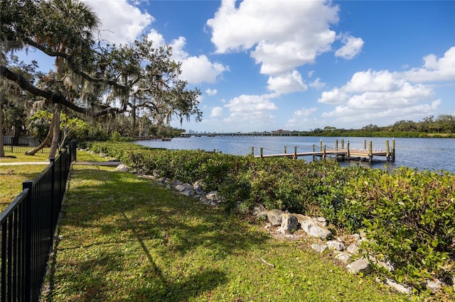 dock area with a water view and a lawn