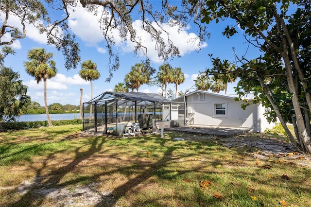 view of yard featuring a patio area, a lanai, and a water view